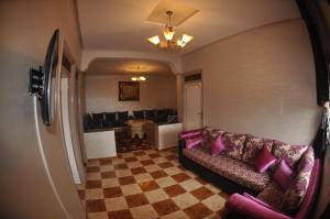 een woonkamer met een bank en een geruite vloer bij Jbel Moussa Lodge in Rcham