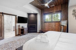 een slaapkamer met een groot bed en een televisie bij Gondola Vista Luxury Villas by Ski Heavenly & Beaches in South Lake Tahoe