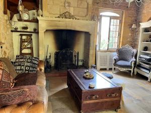 a living room with a couch and a fireplace at Maison périgourdine avec spa in Saint-Cyprien