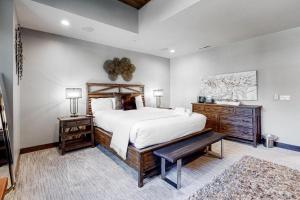 um quarto com uma grande cama branca e um banco em Gondola Vista Luxury Villas by Ski Heavenly & Beaches em South Lake Tahoe