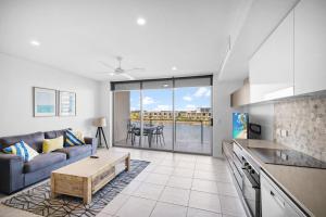 a living room with a couch and a table at North Shore Oceanside Kawana in Kawana Waters