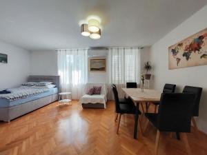 a living room with a dining room table and a bed at Apartment Andry 2 in Crikvenica