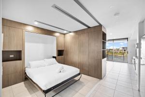 1 dormitorio con cama y ventana grande en North Shore Oceanside Kawana, en Kawana Waters