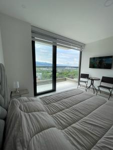 a bedroom with a large bed and a large window at Apartaestudio de lujo en Cali in Cali