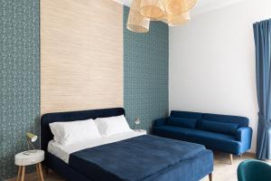 Sapore di Mare al Borgo في جيتا: غرفة نوم بسرير ازرق واريكة زرقاء