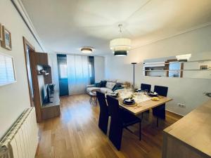 a dining room and living room with a table and chairs at Casa Río Duero in Soria