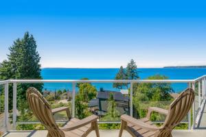 un balcone con due sedie e vista sull'oceano di Driftwood Retreat Upstairs a Blaine