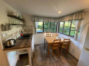 cocina con mesa de madera y algunas ventanas en Chata pod pindulou en Rožnov pod Radhoštěm