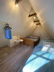 1 dormitorio con cama y mesa en el ático en Chata pod pindulou en Rožnov pod Radhoštěm