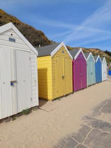 a row of colorful beach huts on a beach at Apartment in Boscombe close to beach in Bournemouth