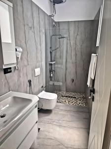 y baño con ducha, aseo y lavamanos. en Suloti House Lungomare, en Vlorë