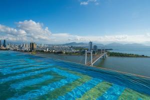 a large swimming pool with a view of the city at Dana Pearl Bay in Danang