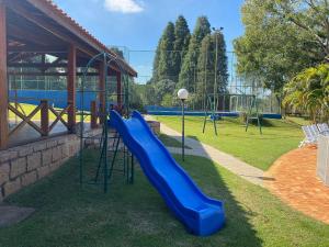 a playground with a blue slide in a park at Sítio em Porto Feliz - Aconchegante e Ideal para Crianças in Pôrto Feliz