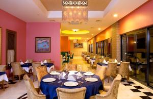 a dining room with tables and chairs and a chandelier at Venosa Beach Resort & Spa - All Inclusive in Didim