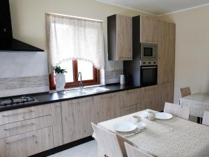 cocina con mesa, fregadero y ventana en Villa La Torre, en Pagliara