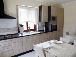 a kitchen with a table and a sink and a window at Villa La Torre in Pagliara