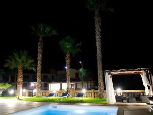 a wedding arch and palm trees at night at Villa La Torre in Pagliara