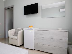 1 dormitorio con tocador y TV en la pared en Villa La Torre, en Pagliara