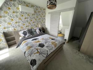um quarto com uma cama com uma parede estampada de flores em bellevue em Coux-et-Bigaroque