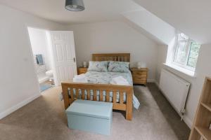 a bedroom with a wooden bed and a window at BRIARS CLOSE - Four Bed Property on the Edge of the Peak District National Park in Buxton