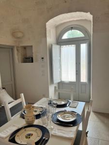 a dining room with a table with plates and glasses at Trullo in vigna in Cisternino