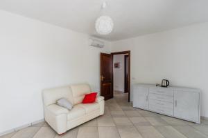 sala de estar con sofá blanco y armario en Appartamento Stelle e Coralli, en Tresnuraghes