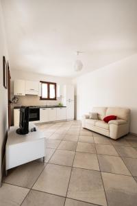 sala de estar con sofá y cocina en Appartamento Stelle e Coralli, en Tresnuraghes