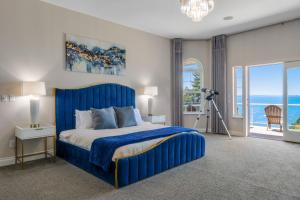 1 dormitorio con cama azul y vistas al océano en Driftwood Retreat, en Blaine