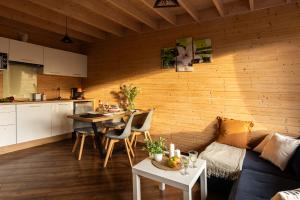 a kitchen and a living room with a table at Domki Sarbinowo Elizjum in Sarbinowo