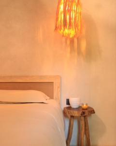 a bedroom with a bed and a table with a chandelier at Indajani Hotel&Hostel Tulum with Pool in Tulum