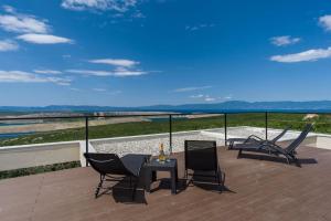 d'une terrasse avec des chaises et une table sur un balcon. dans l'établissement Villa Ventus, à Šmrika