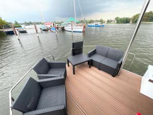 dwa krzesła i stół na pokładzie łodzi w obiekcie Hausboot Edda w mieście Wildau