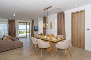a dining room and living room with a table and chairs at Villa Ventus in Šmrika