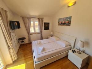 a bedroom with a white bed and a window at Apartments KUĆA SUNCE in Vodnjan