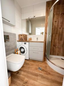 Un baño con inodoro y lavadora. en LuxFlats Apartament Boho, en Jastrzębia Góra