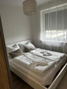 a white bed in a room with a window at City Apartment Nord in Salzburg