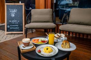 a table with breakfast foods and drinks on it at FIKA Residence in Dois Irmãos