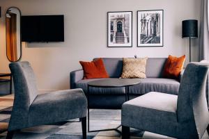 uma sala de estar com um sofá e duas cadeiras e uma mesa em Best Western Plus JA Hotel Karlskrona em Karlskrona
