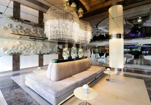 a living room with a couch and a chandelier at The Sanctuary Resort Pattaya, BW Signature Collection in Pattaya South