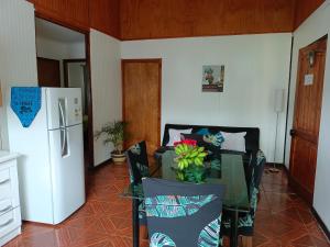 uma sala de estar com uma mesa de vidro e um frigorífico em Cabañas Hua'ai Village em Hanga Roa
