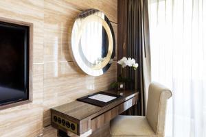 a room with a mirror and a desk with a chair at The Sanctuary Resort Pattaya, BW Signature Collection in Pattaya South