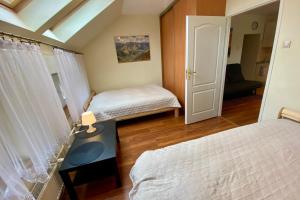 a bedroom with two beds and a table with a lamp at Apartament Kasztanowy Centrum in Zakopane
