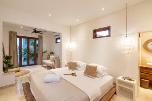 a bedroom with a large bed and a living room at Cozy Up Villa Sanur in Sanur