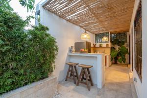 una cocina con 2 taburetes y una barra con barra en Cozy Up Villa Sanur en Sanur