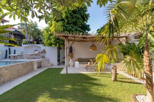 a backyard with a lawn and a house at Cozy Up Villa Sanur in Sanur