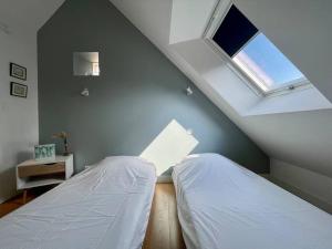 2 letti in una camera con 2 finestre di Logis Saint-Martin by Melrose a Saint-Martin-des-Entrées