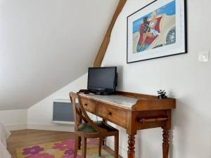 una scrivania con un computer in cima in una stanza di Logis Saint-Martin by Melrose a Saint-Martin-des-Entrées
