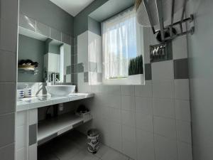 La salle de bains est pourvue d'un lavabo et d'un miroir. dans l'établissement Logis Saint-Martin by Melrose, à Saint-Martin-des-Entrées