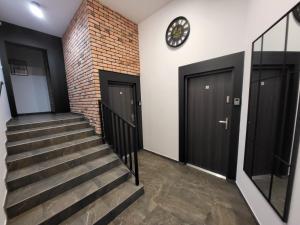 a staircase with two doors and a clock on the wall at Mini Apartamenty Poznań in Poznań
