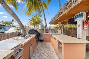 eine Außenküche mit einem Grill und Palmen in der Unterkunft JTs Key Largo Escape in Jewfish